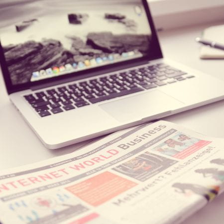 Image of a laptop and newspaper.